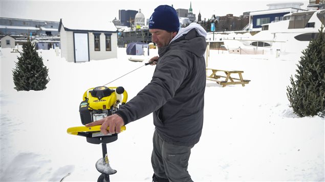 Jean Desjardins, propriétaire de Pêche sur glace Vieux-Montréal, creuse un trou pour la pêche. Photo : Radio-Canada/Marie-Eve Maheu